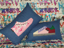 Load image into Gallery viewer, Handmade trainer cushion, rectangular bolster shape with real laces trim on a blue denim base. Approximately 12" x 20" (30cm x 50cm) with a zip opening. Comes with a polycotton cushion inner.