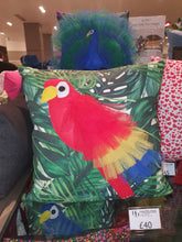 Load image into Gallery viewer, Hazeldee Home Handmade Parrot bird illustration character cushion with 3D feather effect trim.      A great conversational parrot cushion for kids and grown ups alike!  Bring some fun and colour into your space with this handmade cushion with a bold red parrot cushion with plume of red, yellow and blue feather-like trim with a tropical leaf fabric base!  A one-of-a-kind Hazeldee Home design.  Approximately 16" x 16" (40cm x 40cm) with a centre back zip. Comes with a polycotton cushion inner. John Lewis