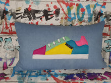 Load image into Gallery viewer, Hazeldee Home Handmade bold colour-block trainer cushion, rectangular bolster shape with real laces trim on a blue denim base. A great conversational trainer cushion for kids and grown ups alike! Bring some fun and colour into your space with this handmade cushion with a trainer with laces detail! Colour-block sneaker trainer cushion with Hazeldee Home label detail. Approximately 12" x 20" (30cm x 50cm) with a zip opening. Comes with a polycotton cushion inner.