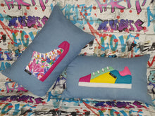 Load image into Gallery viewer, hazeldee Home Handmade bold colour-block trainer cushion, rectangular bolster shape with real laces trim on a blue denim base. A great conversational trainer cushion for kids and grown ups alike! Bring some fun and colour into your space with this handmade cushion with a trainer with laces detail! Colour-block sneaker trainer cushion with Hazeldee Home label detail. Approximately 12" x 20" (30cm x 50cm) with a zip opening. Comes with a polycotton cushion inner.