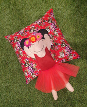 Load image into Gallery viewer, Handmade munchkin cushion inspired by artist Frida Kahlo with trim and legs that extend from the body of the cushion. Designed and handmade by Hazeldee Home, these cushions are a bundle of fun! Each Cushion is one-of-a-kind with bright backgrounds, different skin tones and hairstyles with flowers to match! Frida Kahlo was a Mexican painter known for self-portraits and use of bright colour. Approximately 16" x 16" (40cm x 40cm) with a centre back zip. Comes with a polycotton cushion inner.