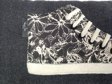 Load image into Gallery viewer, Handmade hi-top trainer cushion, rectangular bolster shape with real laces trim on a black denim base. A great conversational trainer cushion for kids and grown ups alike! Bring some fun and colour into your space with this handmade cushion with a hi-top trainer with laces detail! Black and cream monochrome floral print hi-top sneaker trainer cushion with cream laces and contrast detail.