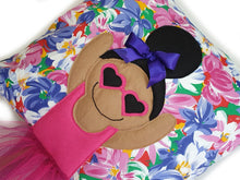 Load image into Gallery viewer, Handmade Munchkin cushion with heart sunglasses with trim and legs and tutu skirt that extend from the body of the cushion. Designed and handmade by Hazeldee Home, these cushions are a bundle of fun! Each Cushion is one-of-a-kind with bright backgrounds, different skin tones and hairstyles with bows to match! Approximately 16" x 16" (40cm x 40cm) with a centre back zip. Comes with a polycotton cushion inner. Each Hazeldee Home Munchkin Cushion comes with a numbered Certificate of Authenticity.