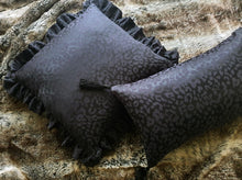 Load image into Gallery viewer, Hazeldee Home handmade black leopard cushion with bold silky black tassels.  Perfect for living rooms and bedrooms alike.  A classy take on leopard that acts as a semi-plain print with silky and mat jacquard.  And of course those tassels add that extra touch of glamour!  Check out the matching Ruffle square cushion!  Both items are Limited Edition one of a kind (for now)...  Approximately 12" x 20" (30cm x 50cm) with a concealed zip.  Comes with a polycotton cushion inner.  Do not wash, Dry Clean Only.