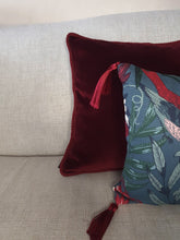 Load image into Gallery viewer, Hazeldee Home Handmade double-sided cushion with a fresh botanical green based wild flower floral print on one side and rich Italian velvet in burgundy on the reverse, edged with a contrasting burgundy intricate interwoven rope.   Inspired by European botanical gardens, this floral print features playfully bold wild flowers with other wildlife in the form of whimsical butterflies berries and tree branches detailed within the print.  A truly enchanting design.