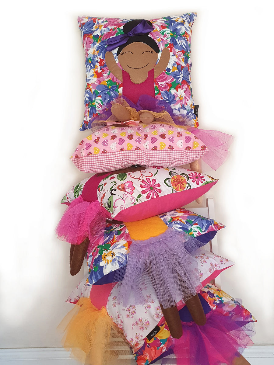 A stack of Hazeldee Home Kids Munchkin Character Cushions in a variety of prints, skin-tones and hairstyles