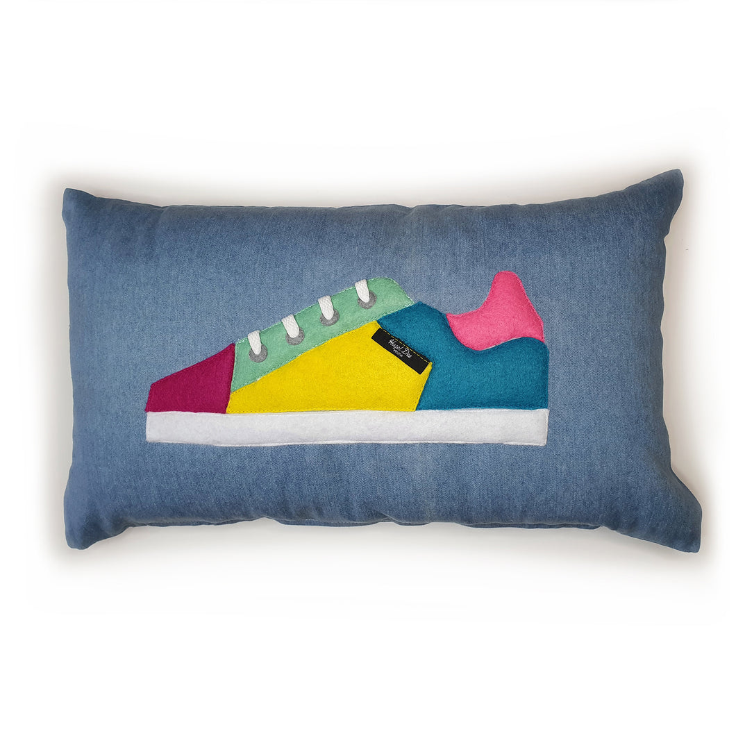 Hazeldee Home Handmade bold colour-block trainer cushion, rectangular bolster shape with real laces trim on a blue denim base.  A great conversational trainer cushion for kids and grown ups alike!  Bring some fun and colour into your space with this handmade cushion with a trainer with laces detail!  Colour-block sneaker trainer cushion with Hazeldee Home label detail.  Approximately 12