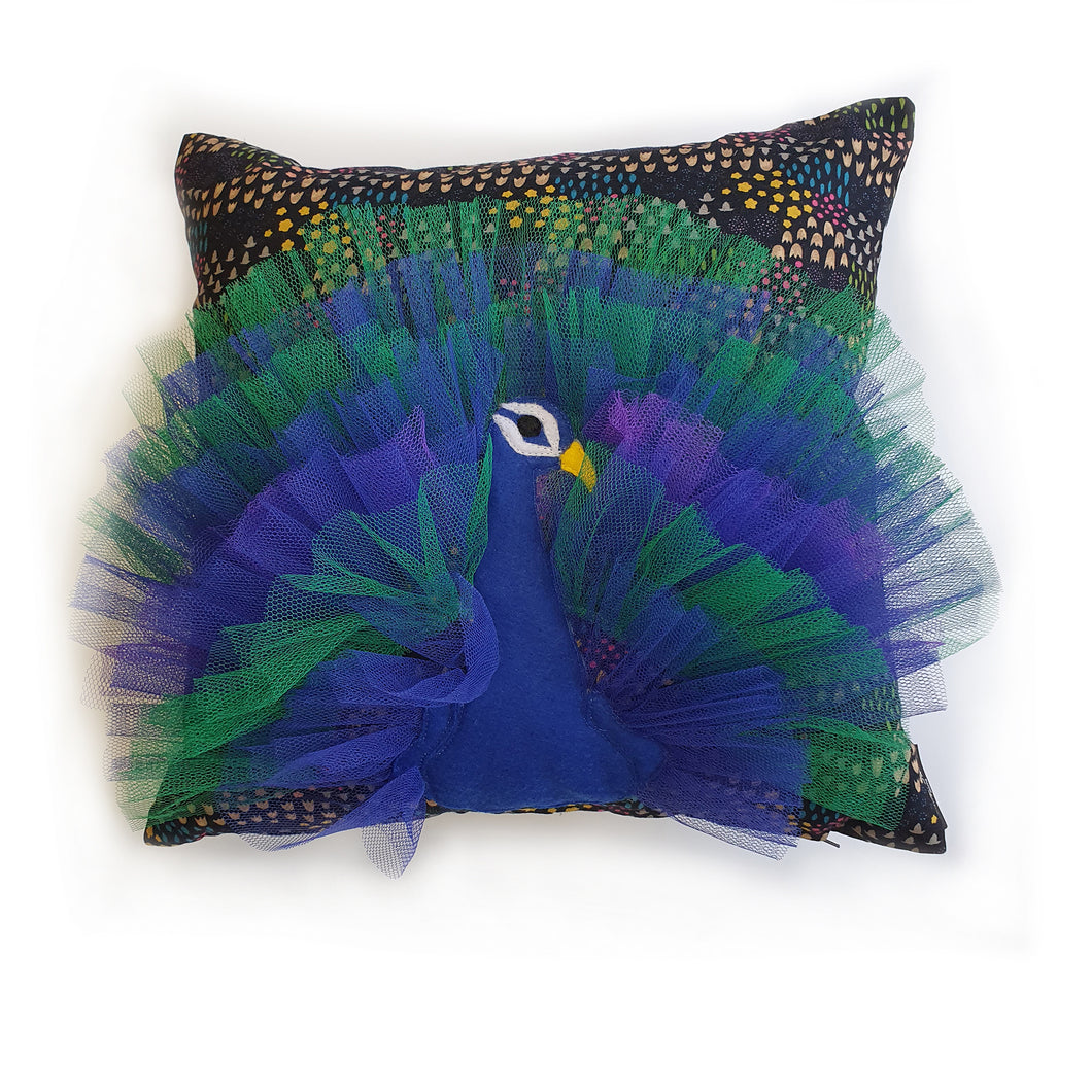 Hazeldee Home Handmade peacock bird illustration character cushion with 3D feather effect trim.       A great conversational peacock cushion for kids and grown ups alike!  Bring some fun and colour into your space with this handmade cushion with a peacock cushion with a plume of blue and green feather-like trim with a navy ditsy floral fabric base!