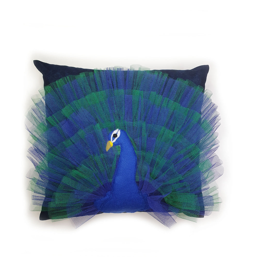 Hazeldee Home Handmade peacock bird illustration character cushion with 3D feather effect trim.       A great conversational peacock cushion for kids and grown ups alike!  Bring some fun and colour into your space with this handmade cushion with a peacock cushion with a plume of blue and green feather-like trim with a navy fabric base!  Hazeldee Home design.  Approximately 16