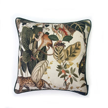 Load image into Gallery viewer, Hazeldee Home Limited Edition Handmade double-sided cushion with an intricate animal design inspired by the African Savannas featuring zebras, leopards, cheetahs, monkeys and more paired back with bold green plants and flowers on a neutral cream background.   The reverse features a tonal cream cotton velvet and forest green cotton piping trim.   This cushion is fully reversible so you get two looks in one!    Approximately 16&quot; x 16&quot; (40cm x 40cm) square with a concealed zip. 
