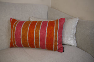 Hazeldee Home One-of-a-kind Limited Edition Handmade bold stripe lumbar cushion using heavy woven fabric with pink, off-white and orange stripe detailing.          Approximately 12" x 20" (30cm x 50cm) with a concealed zip.  Comes with a polycotton lined cushion inner.  Do not wash, Dry Clean Only.