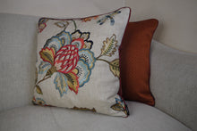 Load image into Gallery viewer, Hazeldee Home Limited Edition Handmade double-sided cushion using the luxurious Colefax and Fowler heavily embroidered floral foliage design fabric on a linen/viscose base on one side and Italian velvet terracotta on the reverse, edged with satin trim.   The front features an intricate floral design reminiscent of a tudor floral design with hues of rust, gold, navy light and mid blues on a linen blend neutral base with a subtle herringbone semi-plain weave that adds dimension depth and interest.  
